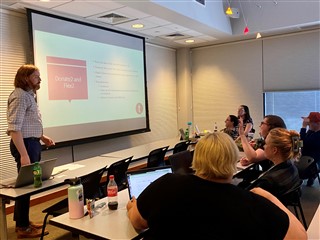 A group of people look at a presentation on a screen