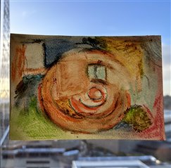 Image of abstract pastel drawing made by Jessie stuck on a window. 